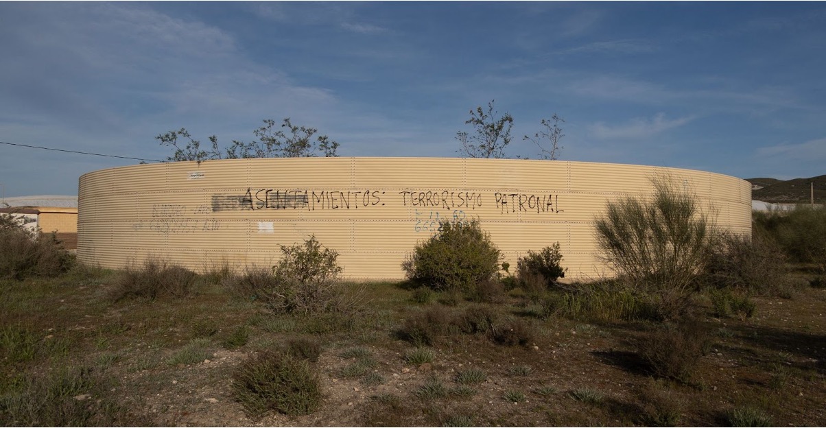 Graffiti on a water tank in the greenhouses reads “Settlements: employer terrorism”, indicating the stranglehold that industrial farming has on its informal employment of migrant workers.
